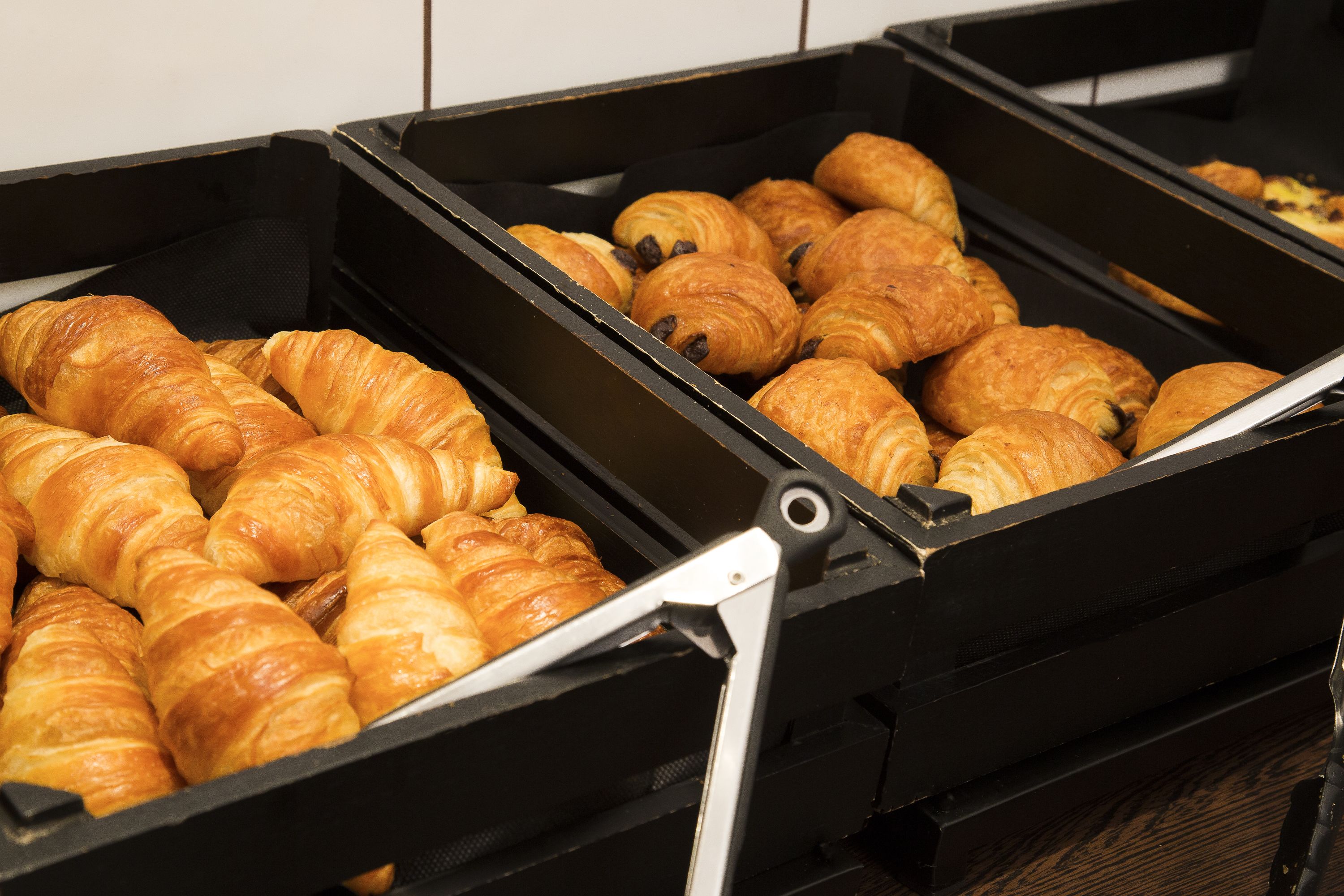 A bakery display with various types of croissants.