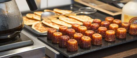 Ein Frühstücksbuffet mit verschiedenen Backwaren und einer Kaffeemaschine.