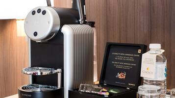 Une machine à café Nespresso, une bouteille d’eau et un assortiment de capsules de café.