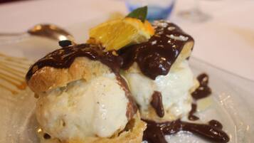 A dessert with chocolate sauce and an orange slice on a plate.