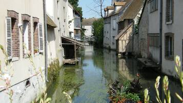 A narrow waterway flanked by traditional buildings with a small boat docked at the side.