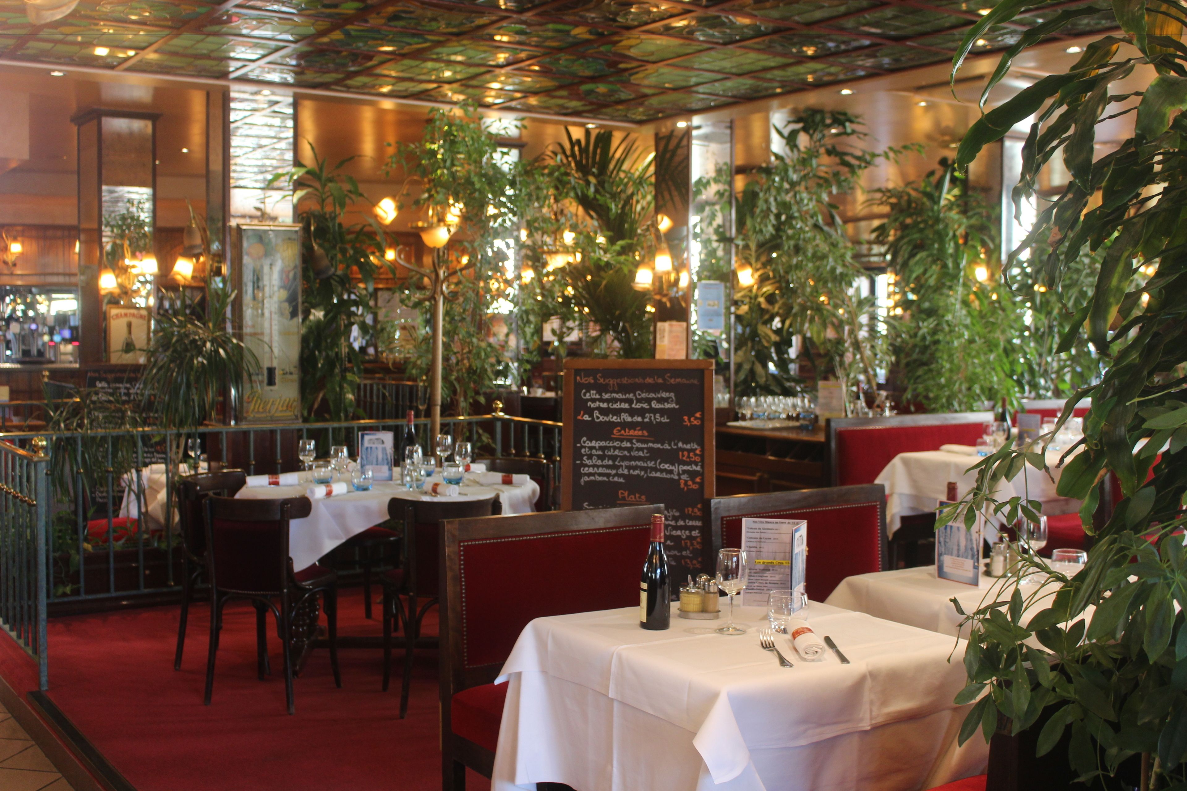 Een restaurantinterieur met gedekte tafels, een menubord en sfeerverlichting.