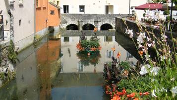 A canal with a bridge, buildings, and a flower bed.