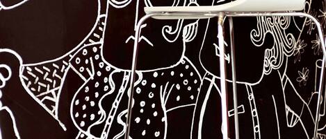 A close-up of a black surface with white line drawings of various figures and patterns.