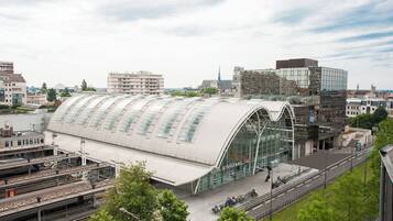 Una estación de tren moderna con un techo grande y curvo y varias vías.