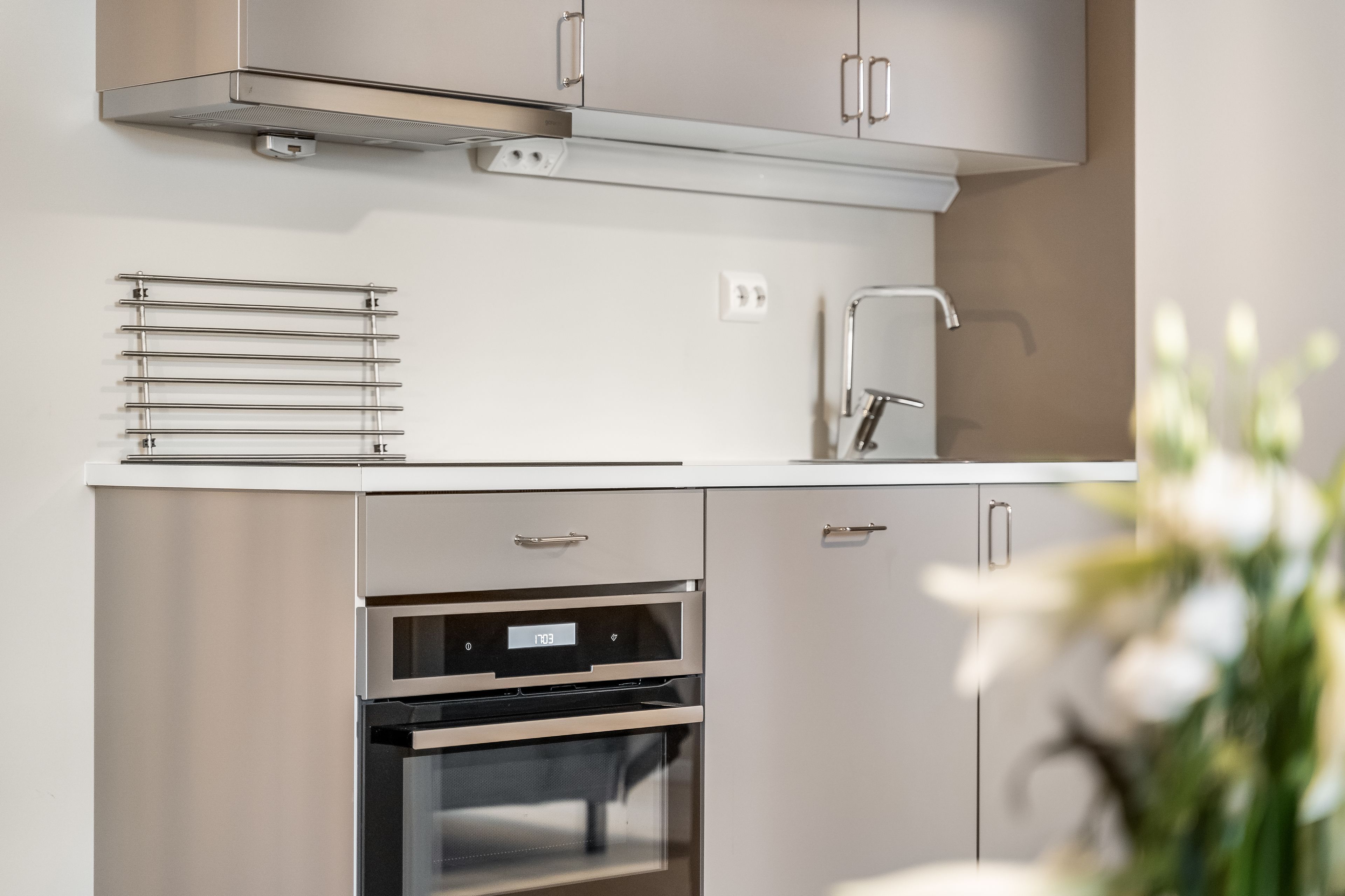 Eine moderne Küche mit Edelstahlgeräten, einem eingebauten Ofen und einer eleganten Arbeitsplatte.