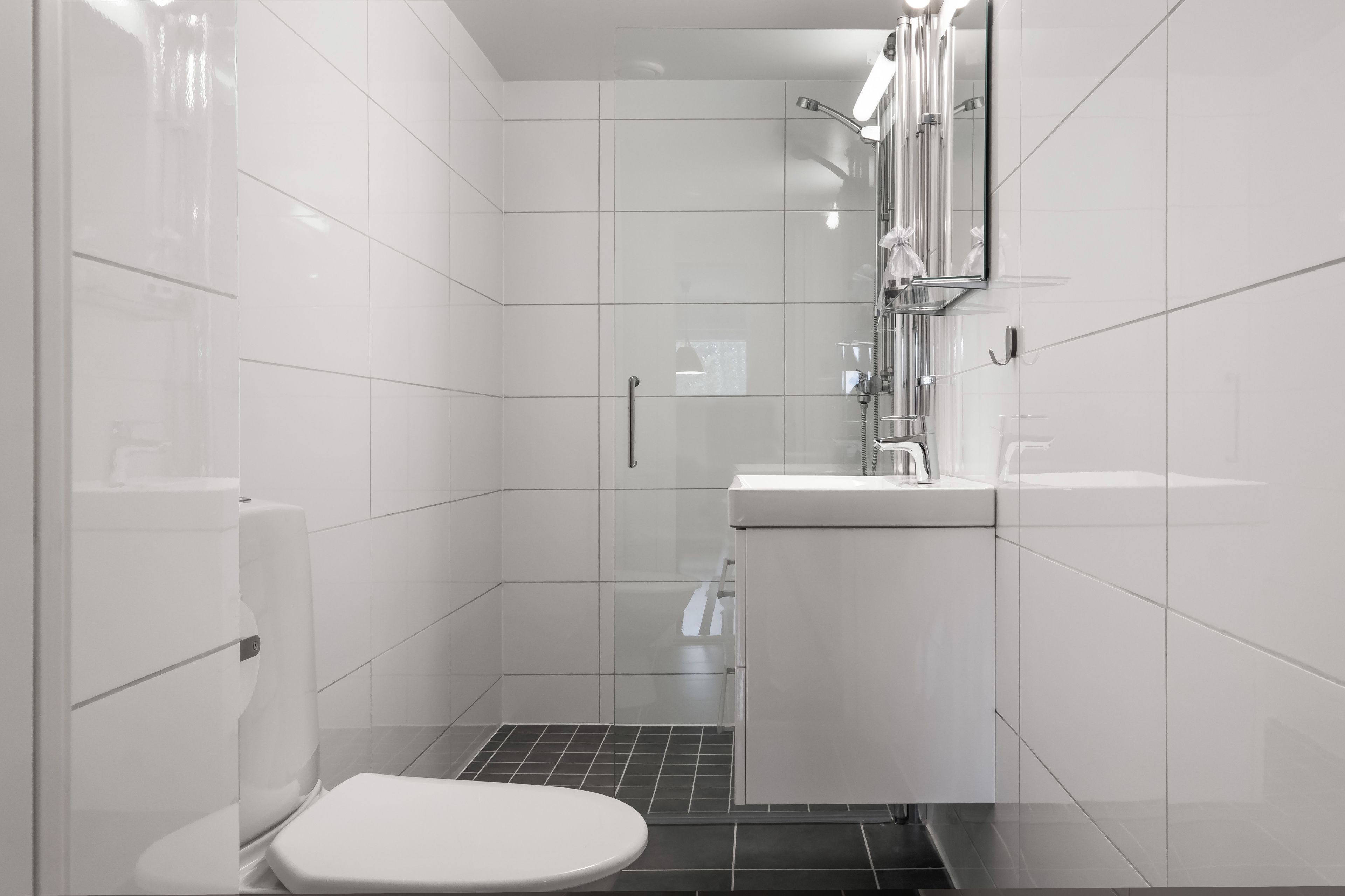 A modern bathroom with a toilet, shower, and sink.
