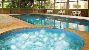An indoor swimming pool with a hot tub area, surrounded by brick walls and large windows. - Best Western Geelong Motor Inn & Serviced Apartments (Geelong)