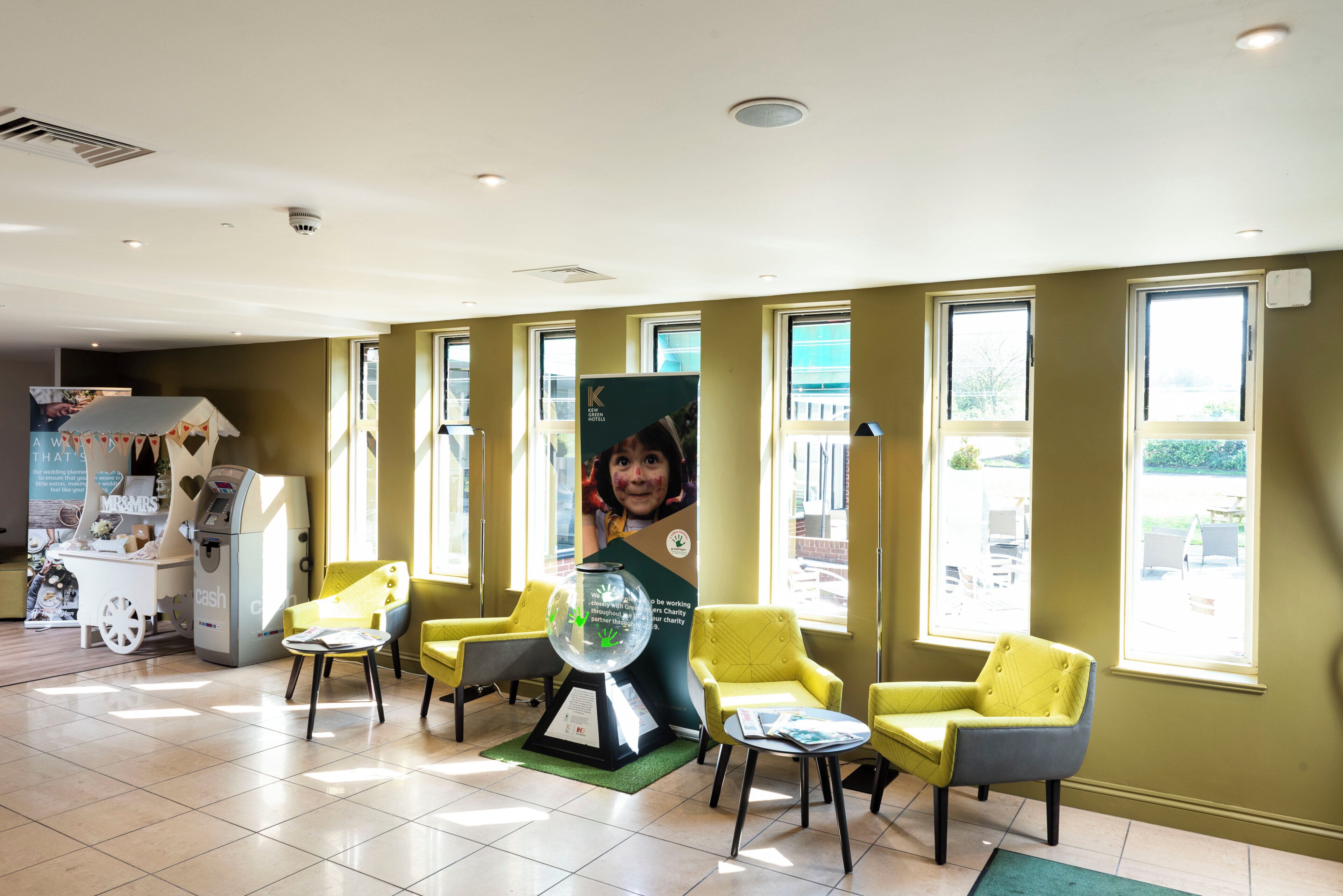 Een receptie met een balie, stoelen en een groot poster.