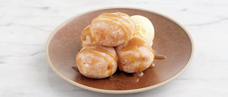 A plate with three pastries and a scoop of ice cream.