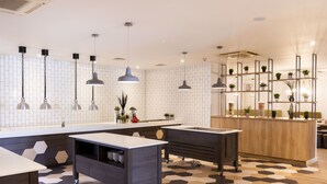 Una cocina moderna con una isla central, iluminación colgante y piso estampado.