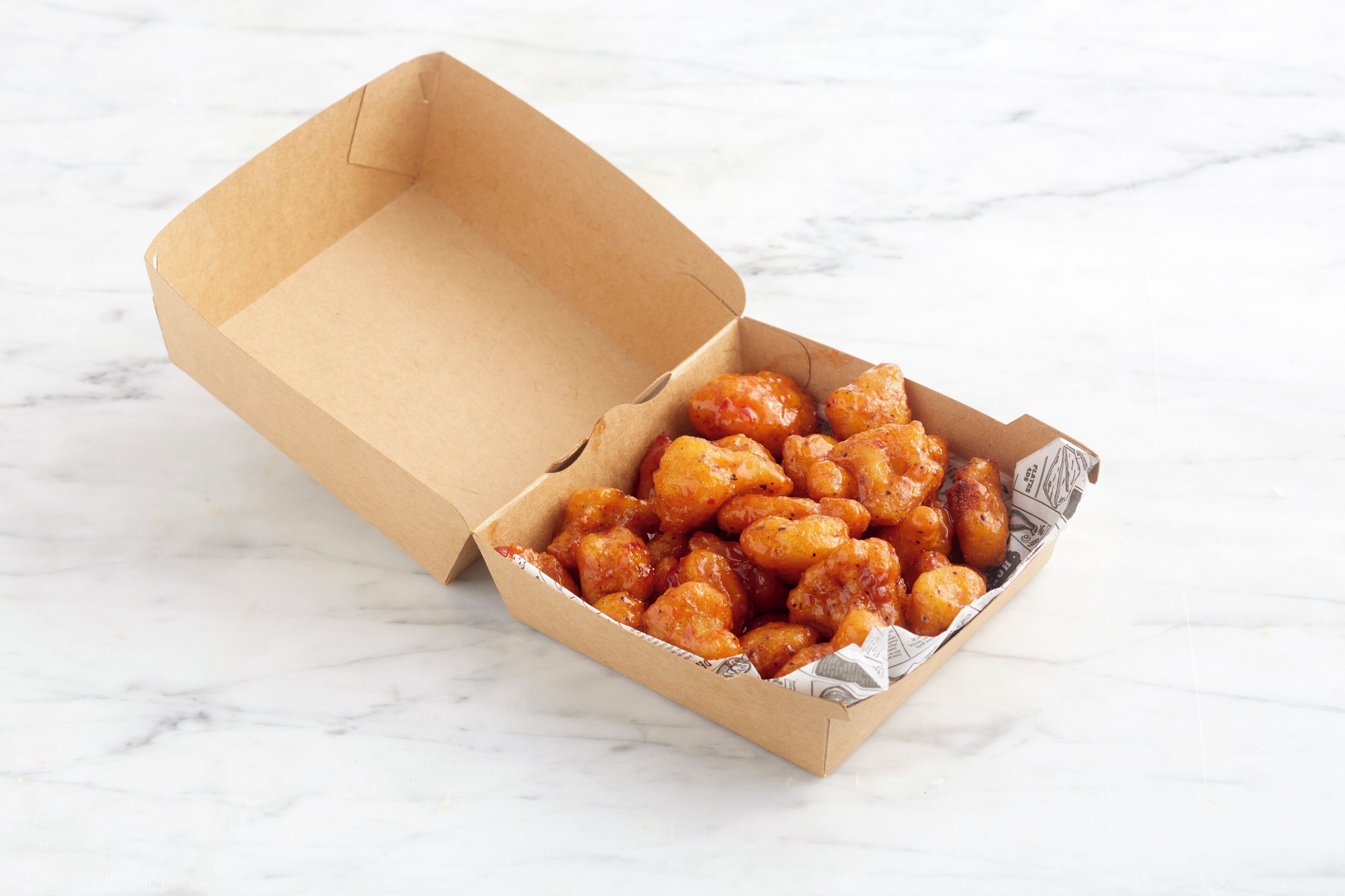 A cardboard box with a white interior containing a food item.
