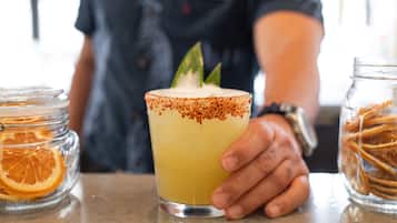 Een hand die een margarita vasthoudt, met een zoutrandje en een limoen.