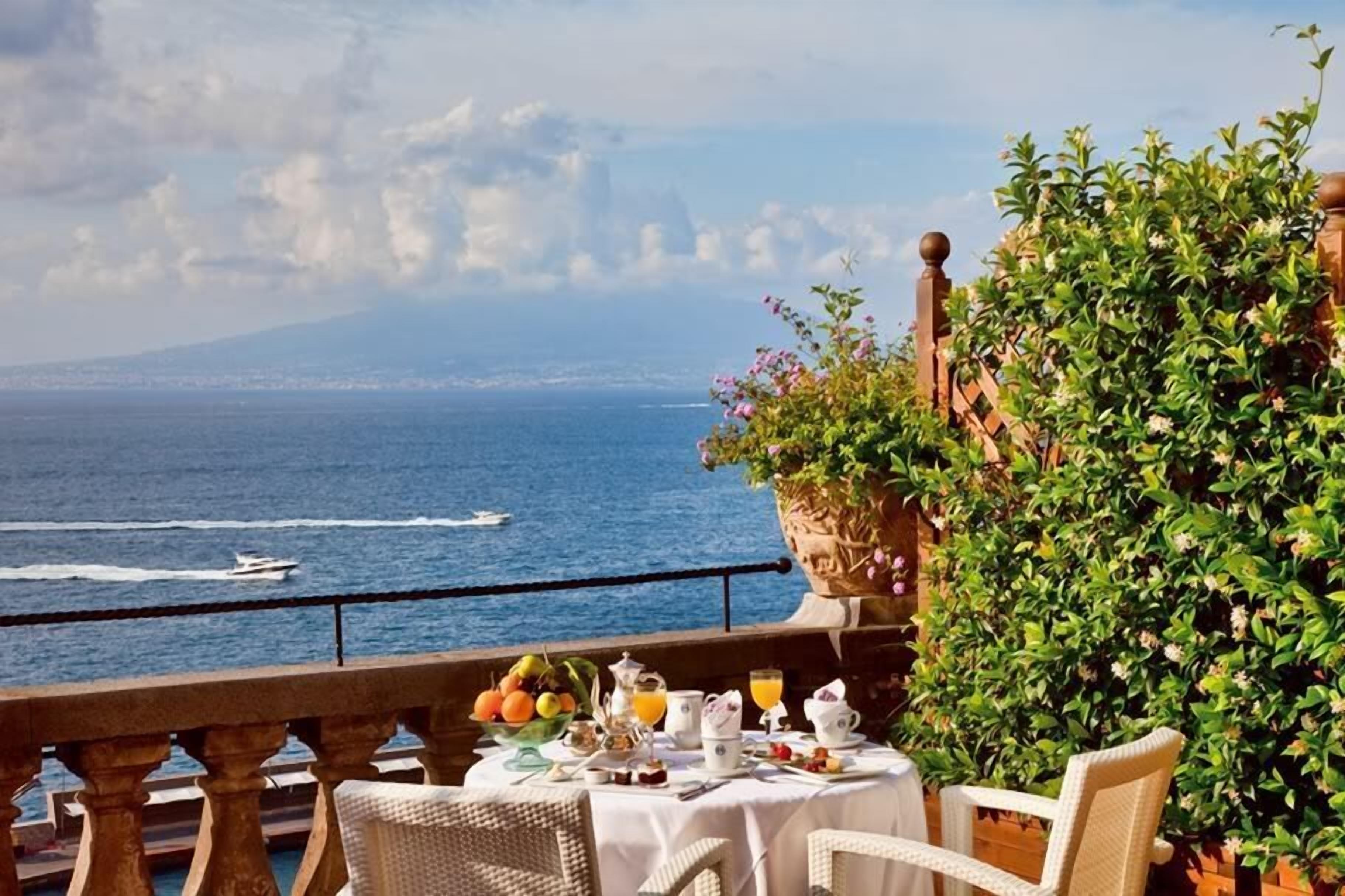 A table set with breakfast items overlooking the sea.