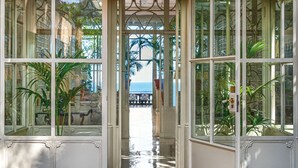 Entrada de vidrio a un edificio con un letrero que dice 'Excelsior Vittoria'.
