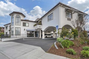 Experience the elegant entrance of this hotel, featuring a grand arched doorway and beautifully manicured grounds.