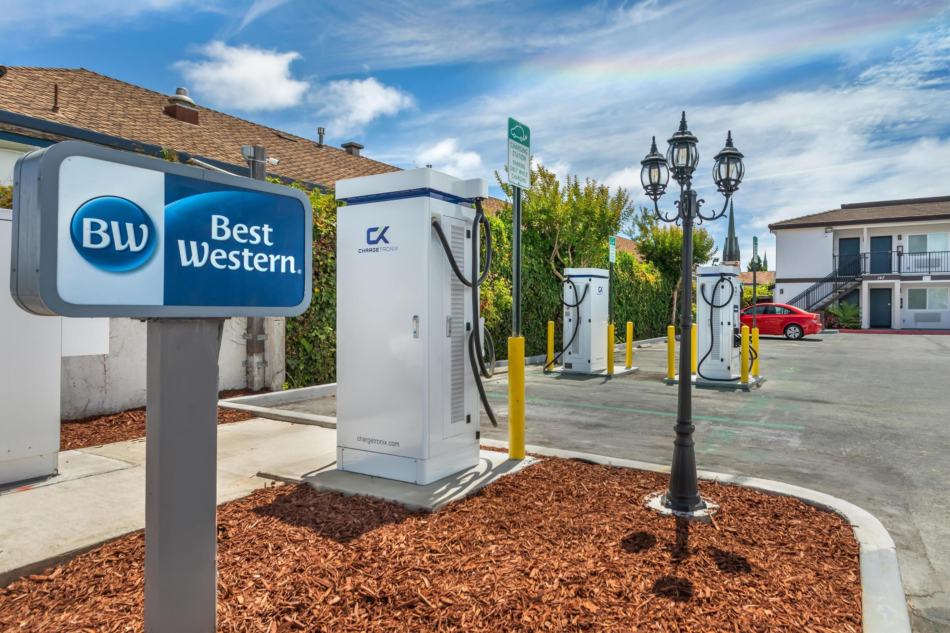 A Best Western hotel sign, electric vehicle charging stations, and a parking area.