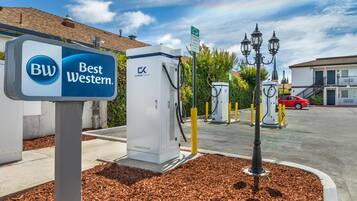 Señal de un hotel Best Western, estaciones de carga para vehículos eléctricos y un área de estacionamiento.
