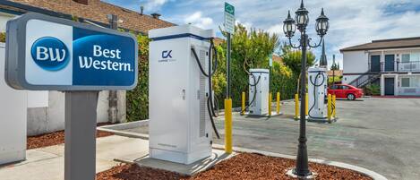 A Best Western hotel sign, electric vehicle charging stations, and a parking area.