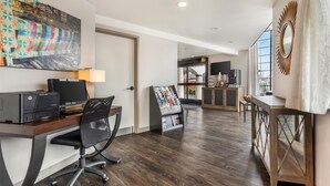 A modern office space with a wooden desk, office chair, and a large abstract painting. - Best Western Rose Garden Inn (Watsonville)