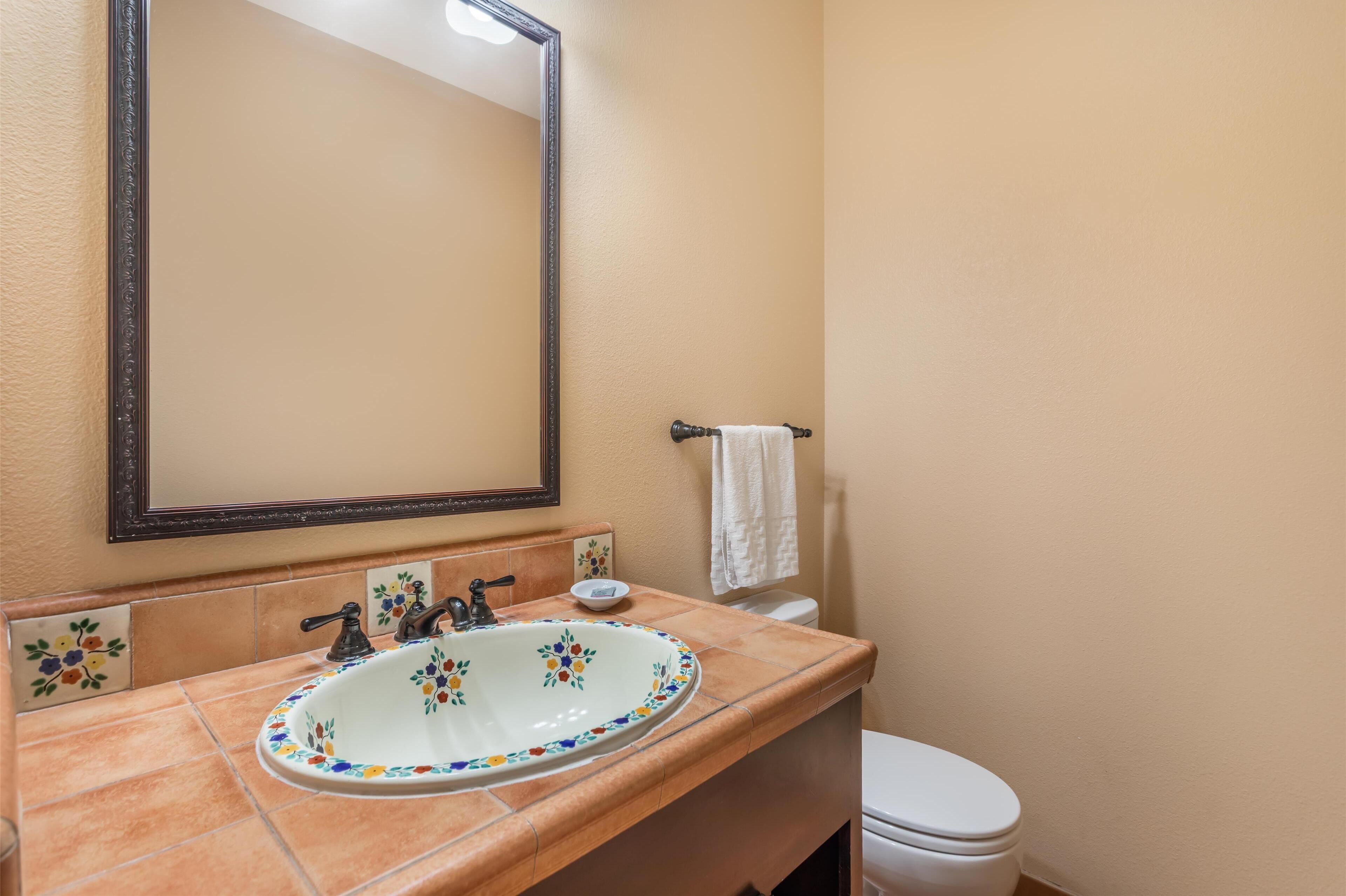 A bathroom with a white sink, a mirror, and a toilet.