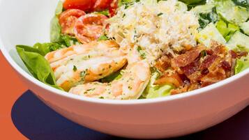 Ensalada con camarones, aguacate, tocino y queso.