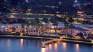 A waterfront hotel with a dock, palm trees, and a golf course in the background. - Coronado Island Marriott Resort & Spa (Coronado)