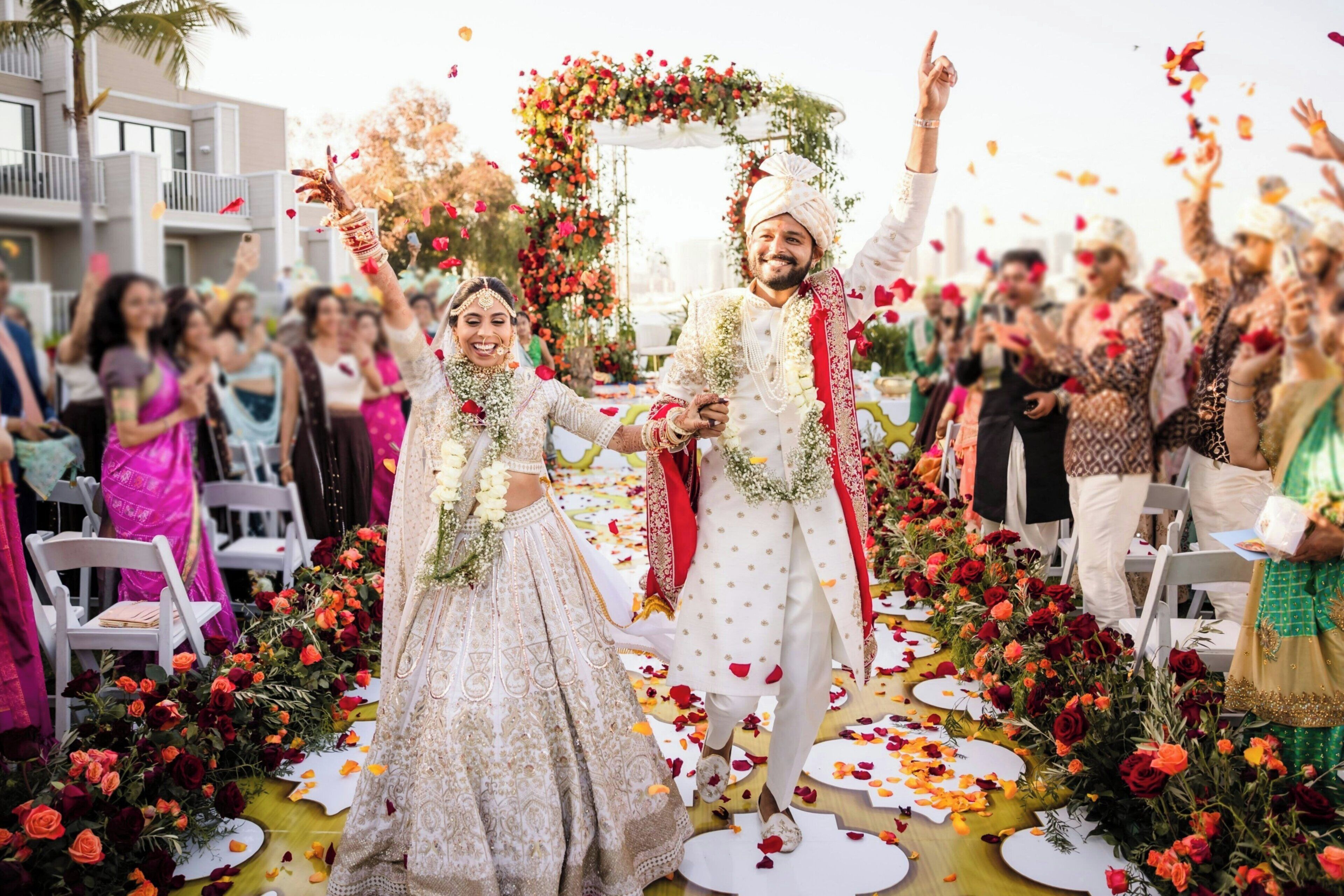Ceremonia de boda con invitados sentados en sillas, un pasillo decorado y arreglos florales.