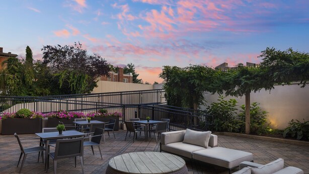 A patio area with outdoor seating, a round table, and a sofa.