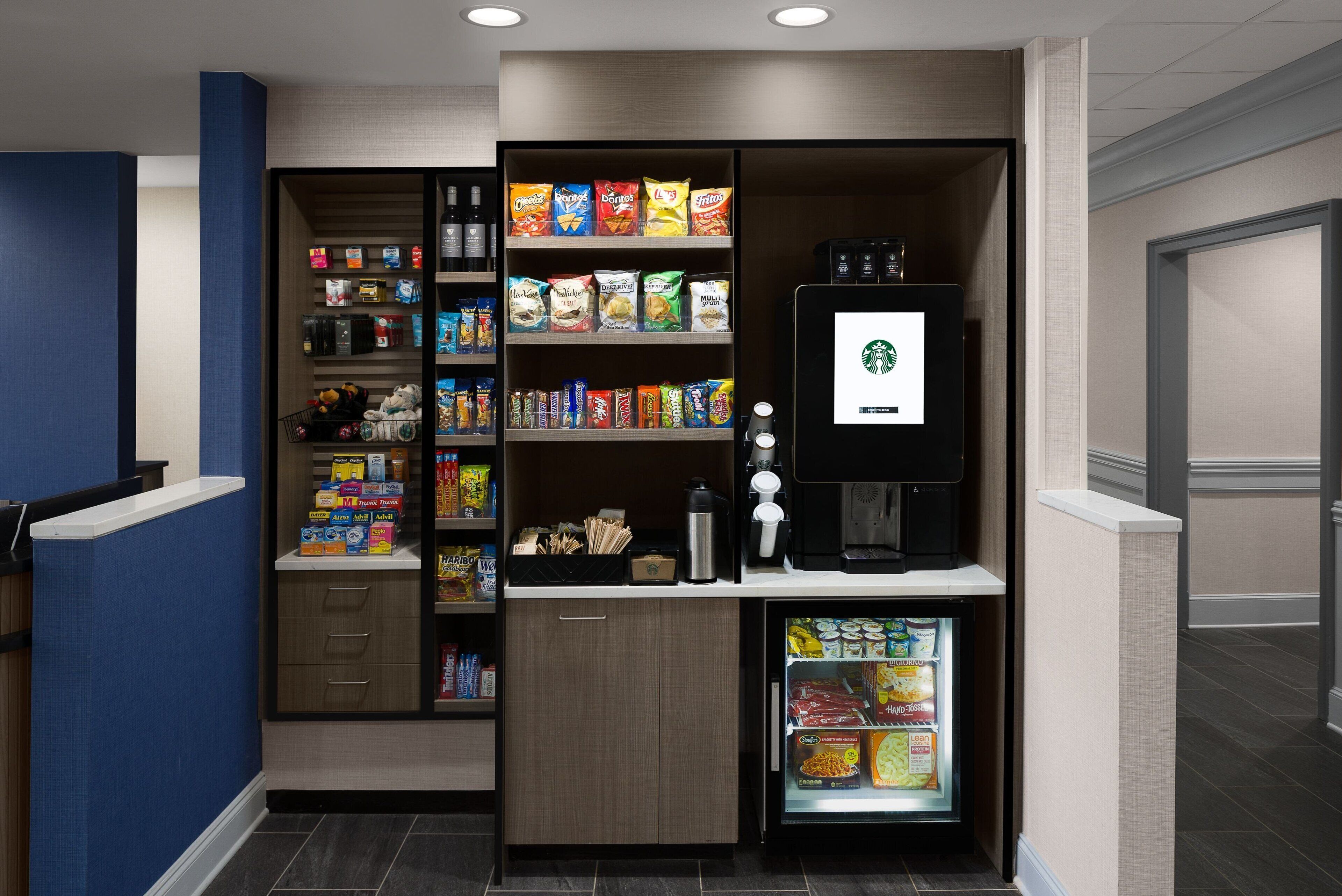 A self-service kiosk with snacks, a coffee machine, and a refrigerated display.