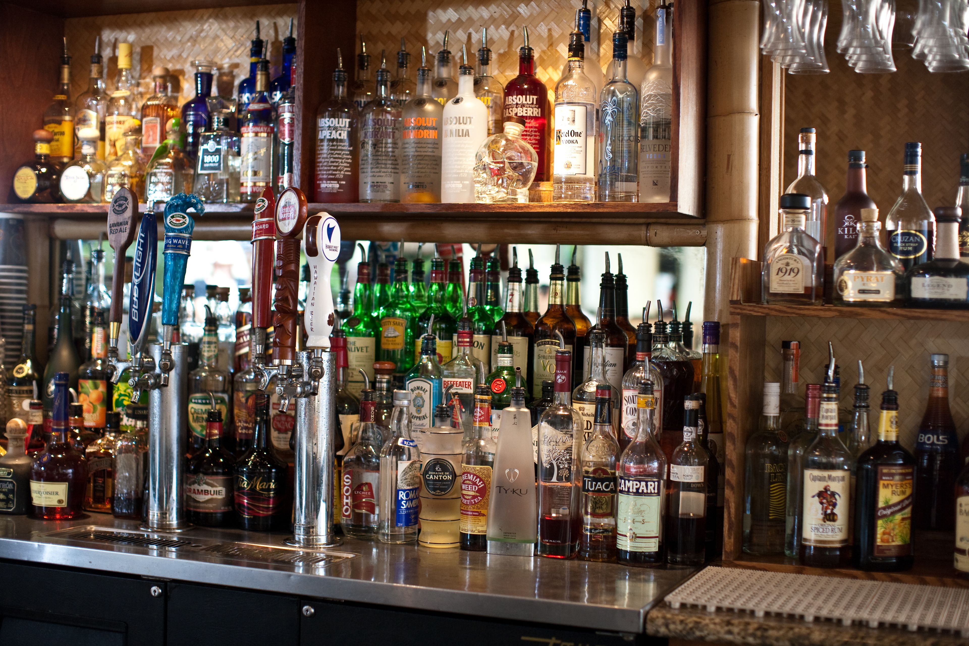 Un bar con una variedad de botellas de licor y un sistema de grifos.