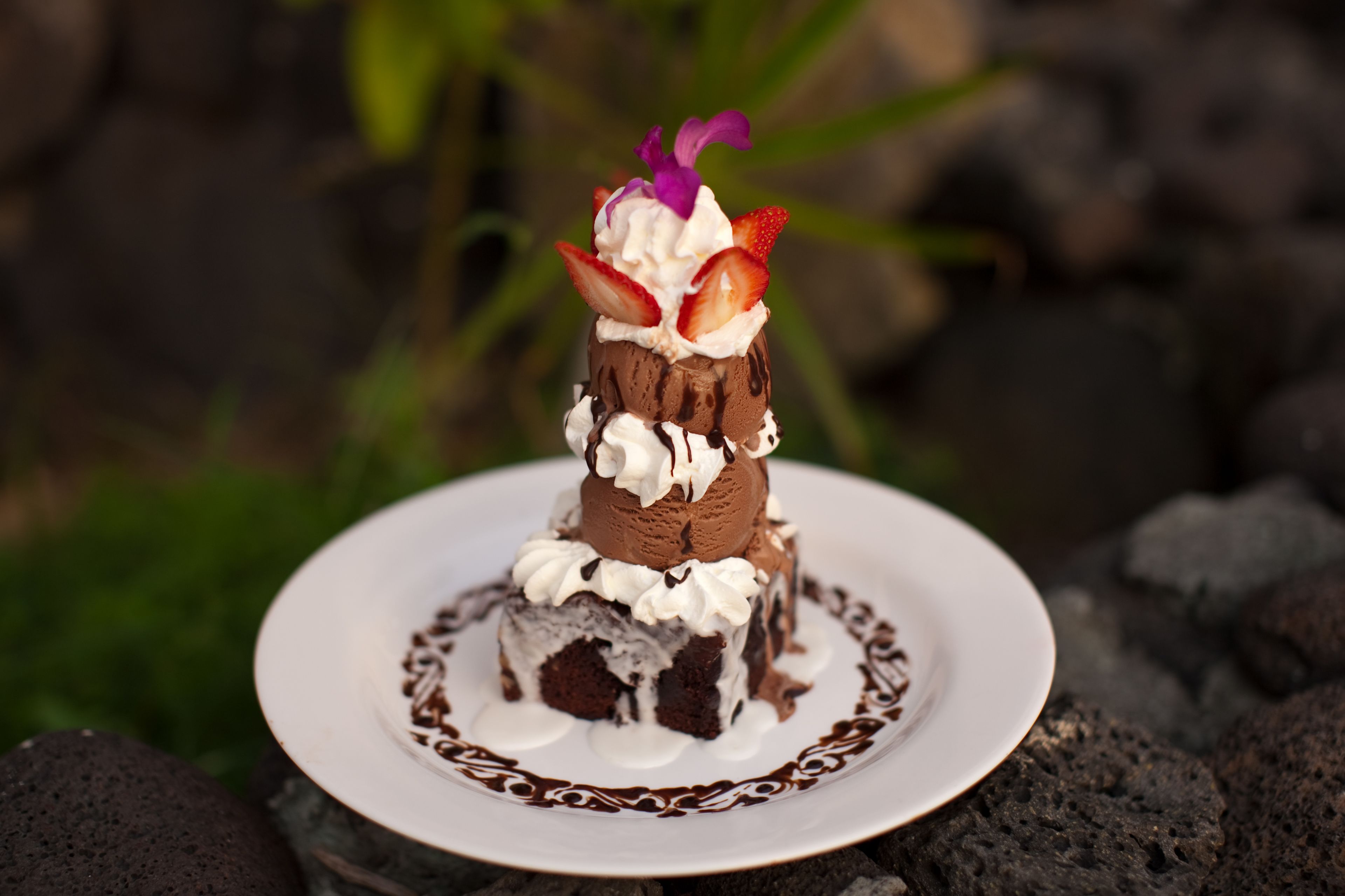 Un dessert présenté sur une assiette ornée d’un bord décoratif, posée sur une surface dont le fond est naturel.