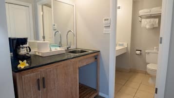 Un baño moderno con lavamanos, espejo y retrete.