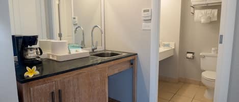 Un baño moderno con lavamanos, espejo y retrete.