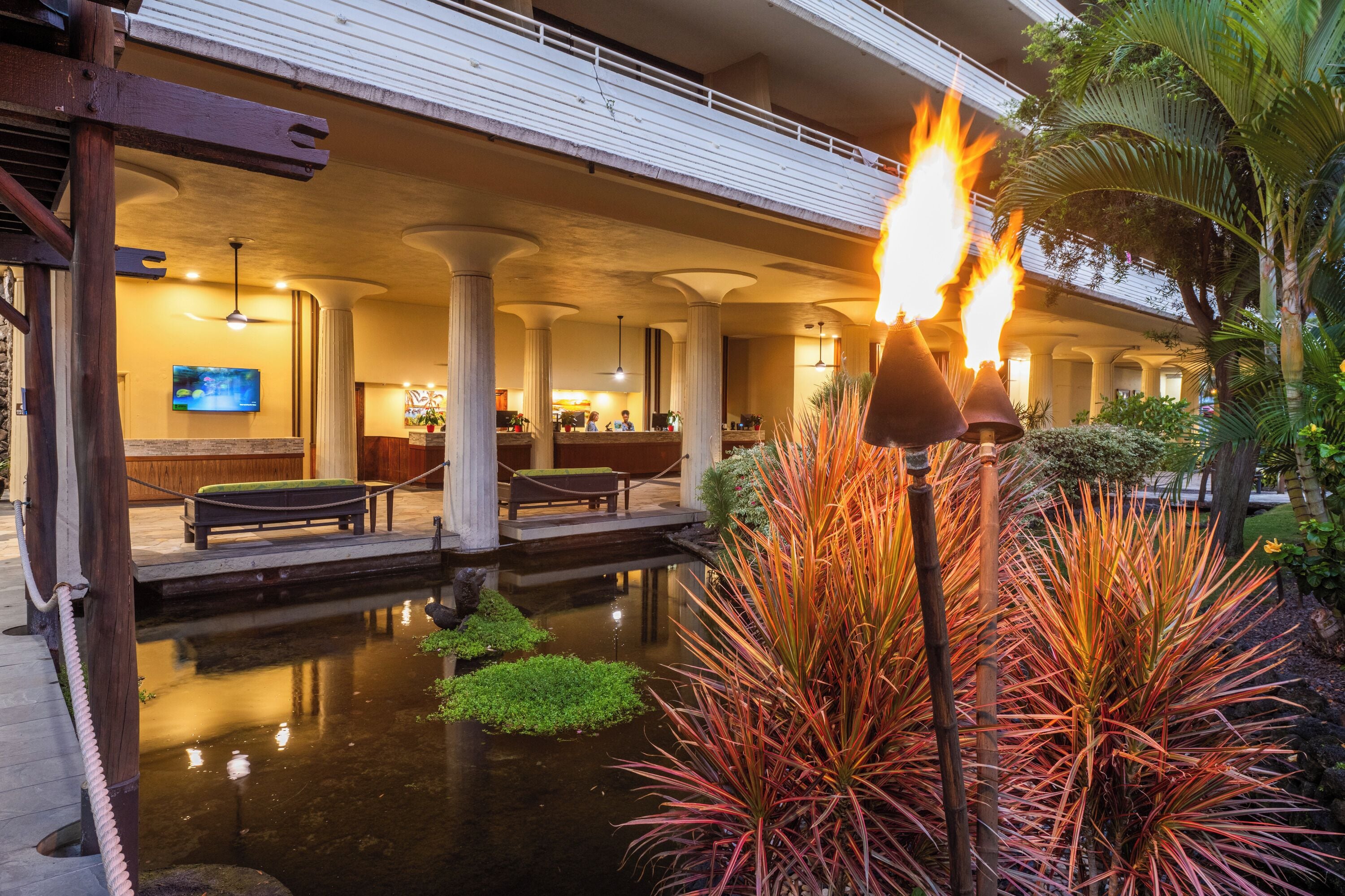 A hotel lobby with a pool, a fire feature, and a television.