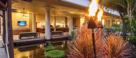 A hotel lobby with a pool, a fire feature, and a television.