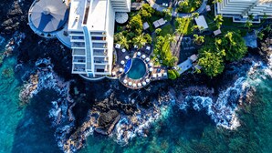An aerial view of a resort with a pool, multiple buildings, and a rocky coastline. - Royal Kona Resort (Kailua-Kona)