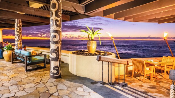 An indoor area with a view of the ocean, stone flooring, wooden furniture, and decorative columns. - Royal Kona Resort (Kailua-Kona)