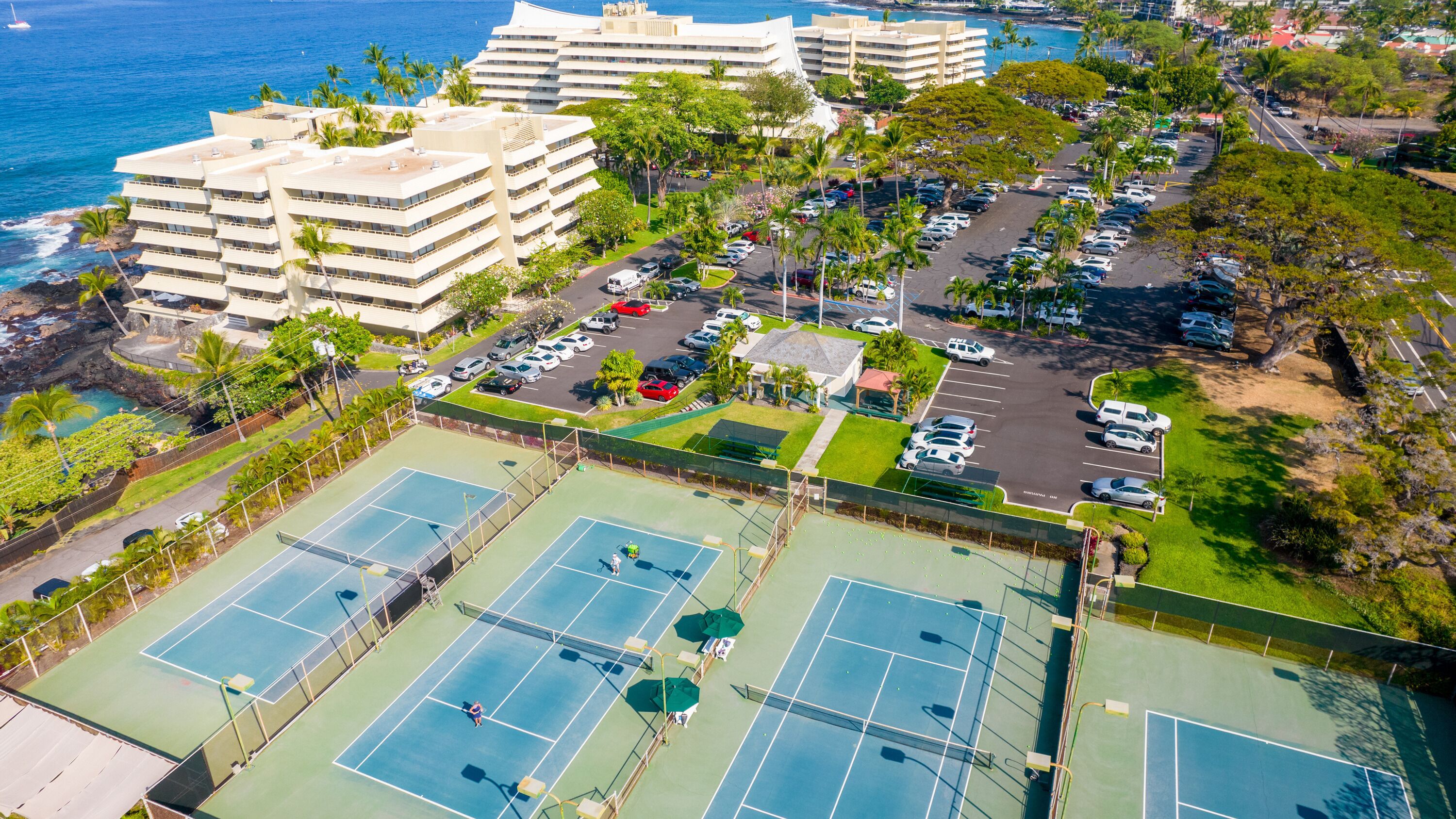 A multi-story hotel with a tennis court complex.