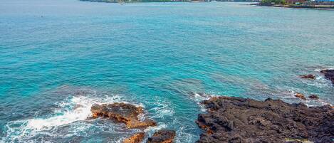 A coastal view with rocky terrain and calm sea.