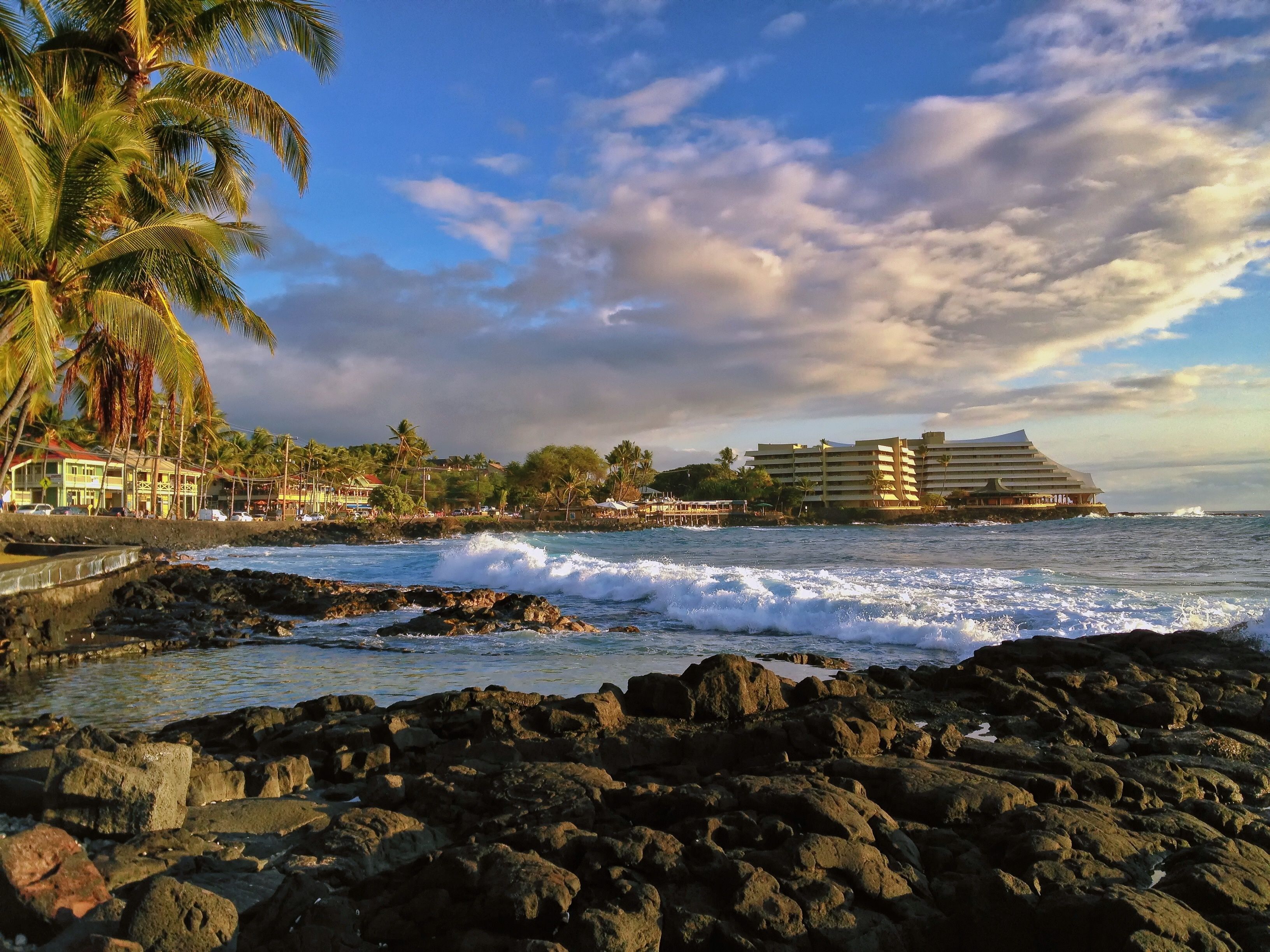 A coastal hotel with a view of the ocean and rocky shoreline.
