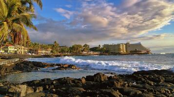 A coastal hotel with a view of the ocean and rocky shoreline.