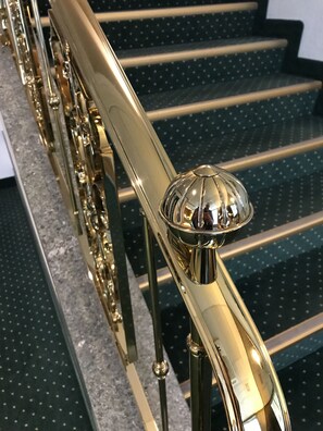 A staircase with a golden handrail and a glass balustrade. - Arlette Am Hauptbahnhof Hotel (Zürich)