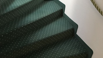 Eine Treppe mit einem grünen Teppich in Punkte.