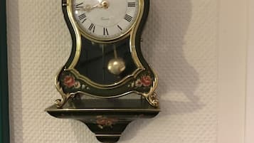A wall-mounted clock with a floral design and a plaque below it.