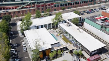 A modern building with a flat roof, large windows, and a parking lot.