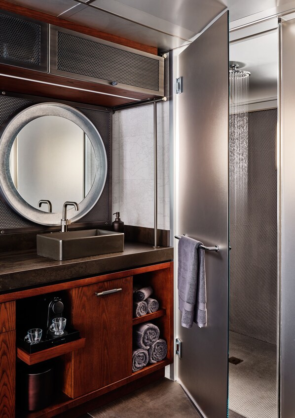 Un baño de diseño moderno, con un espejo grande, un lavabo rectangular, un perchero y una cabina de ducha.
