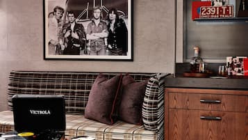 Una sala de estar moderna con un tocadiscos, una fotografía blanco y negro enmarco y una radio antigua.