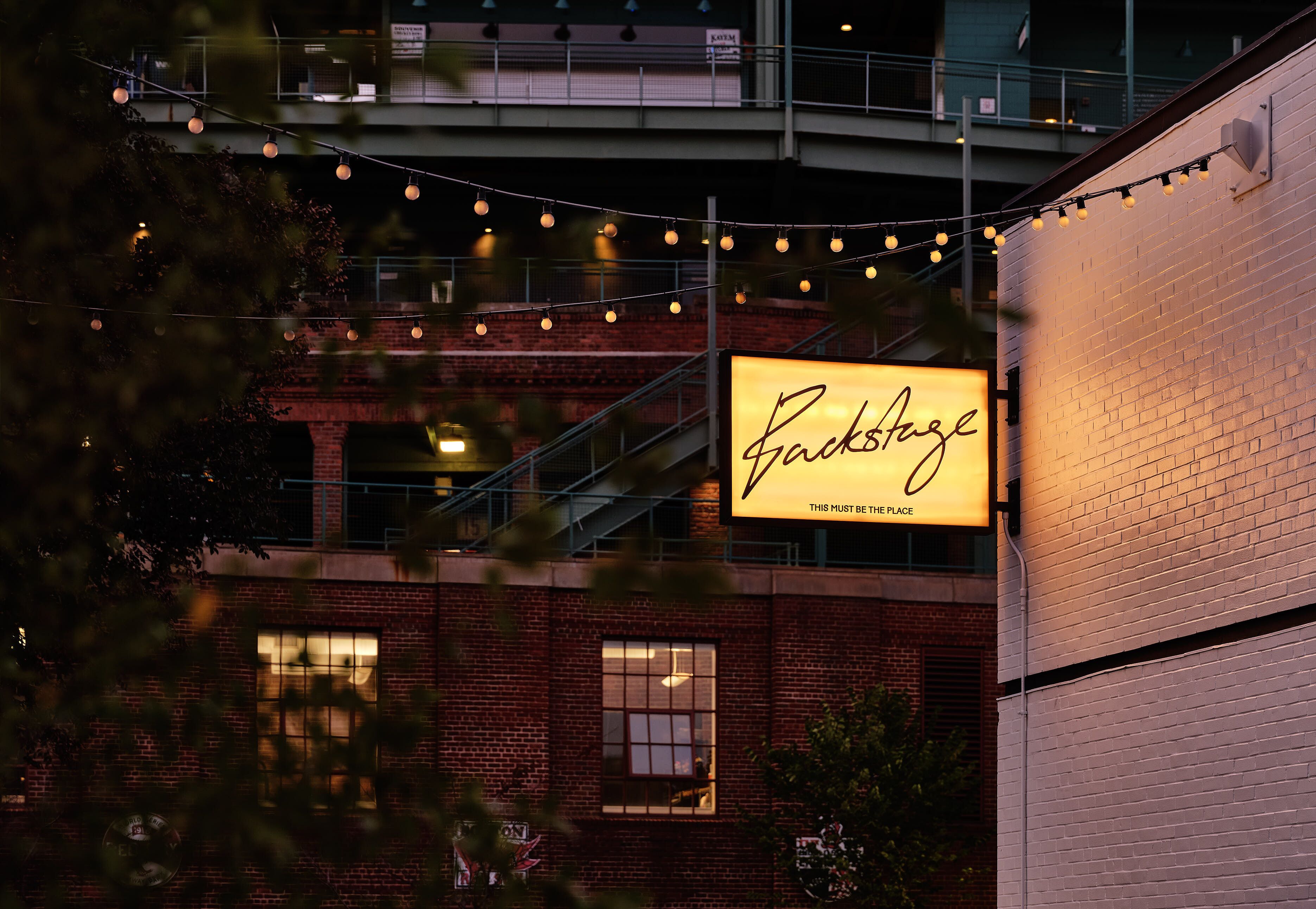 A brick building with a large illuminated sign that reads "RockStage."