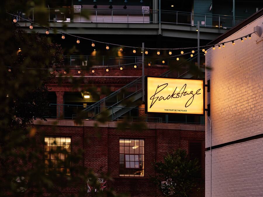 A brick building with a large illuminated sign that reads "RockStage."